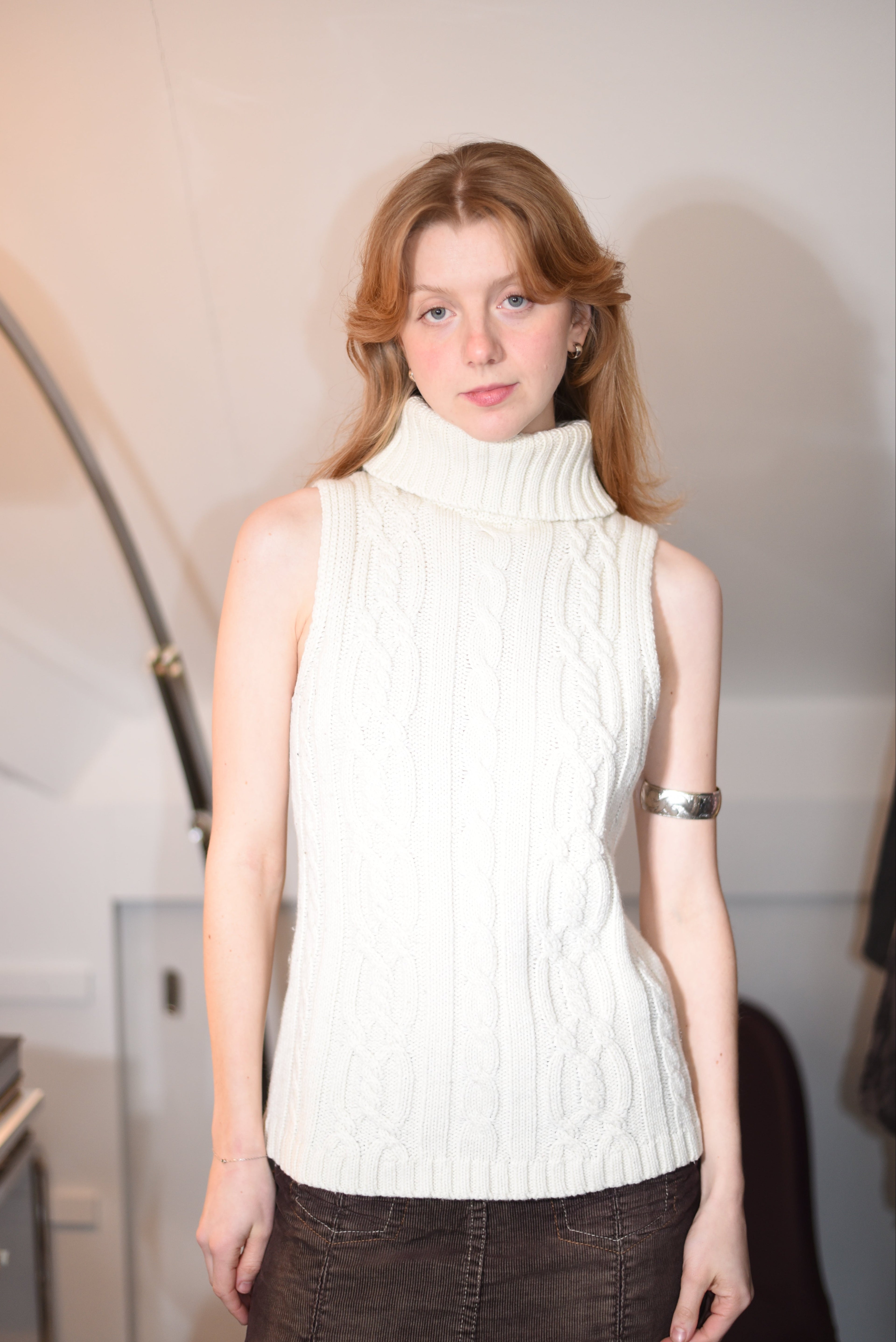 Cream sleeveless cable-knit turtleneck