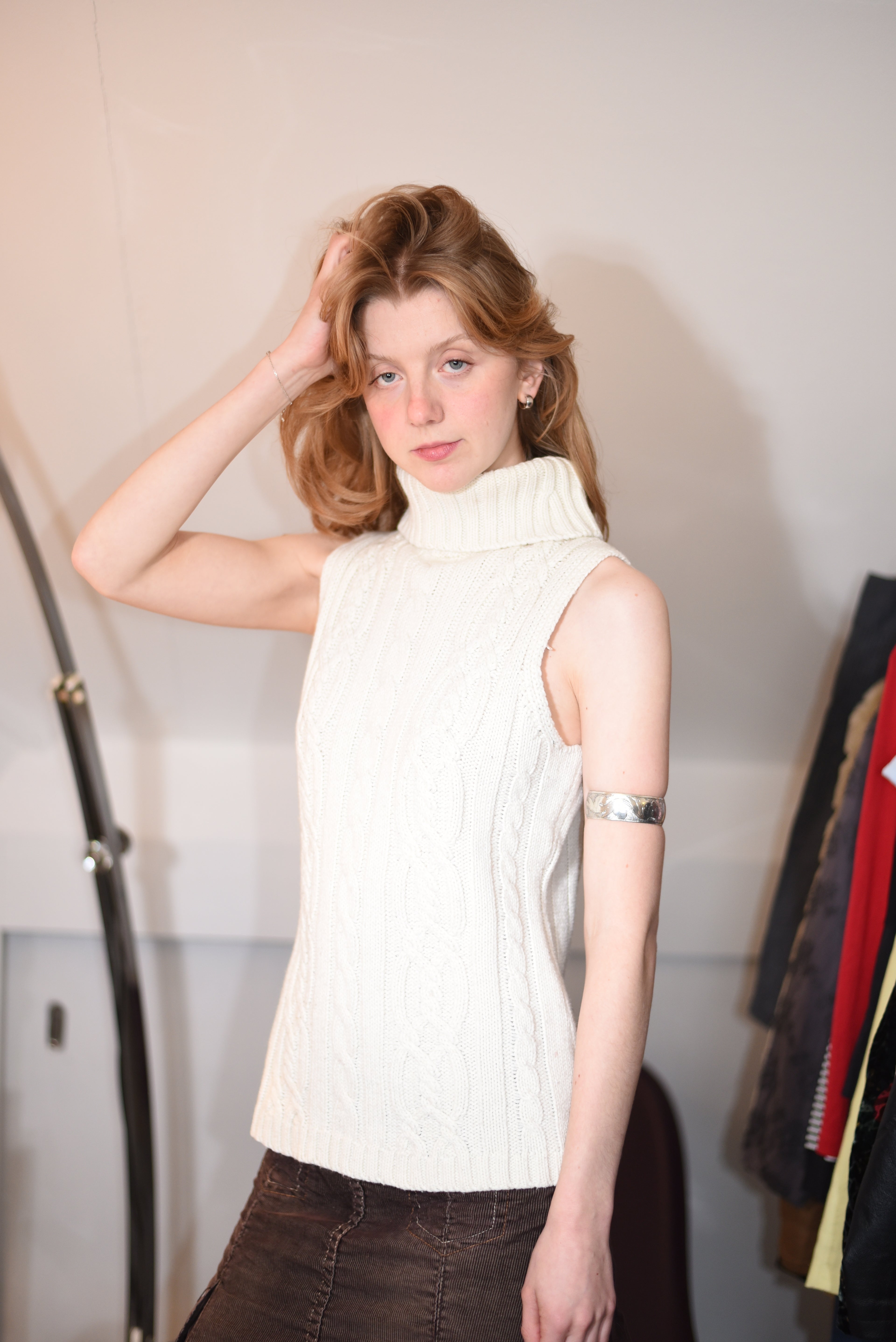 Cream sleeveless cable-knit turtleneck